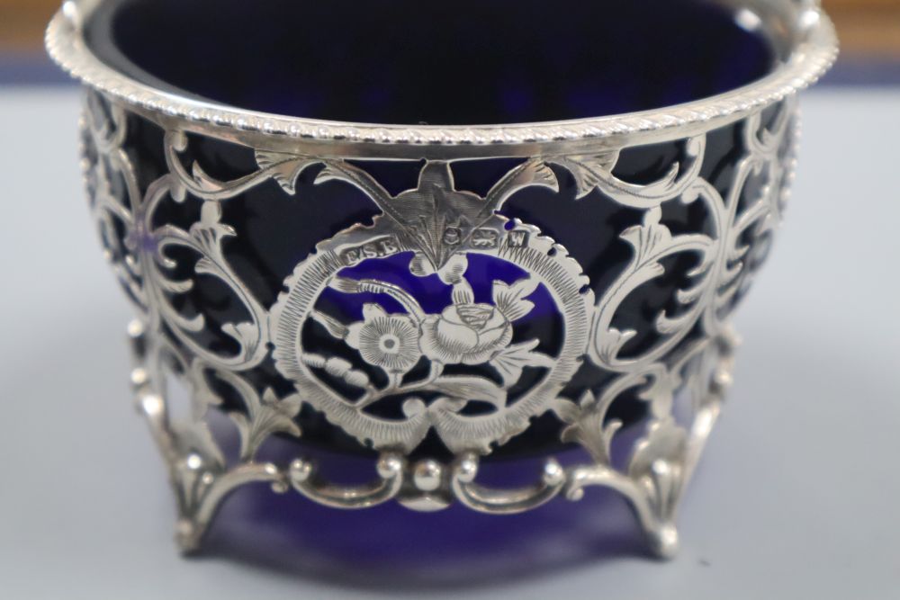 A matched pair of early 20th century pierced silver circular baskets, with blue glass liners